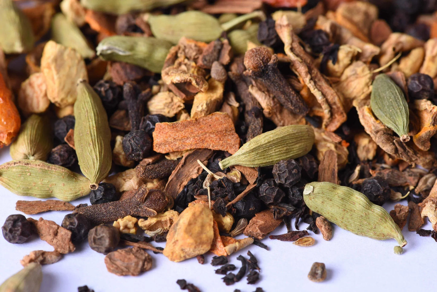 Loose-leaf chai tea blend with cardamom pods, black peppercorns, and dried spices