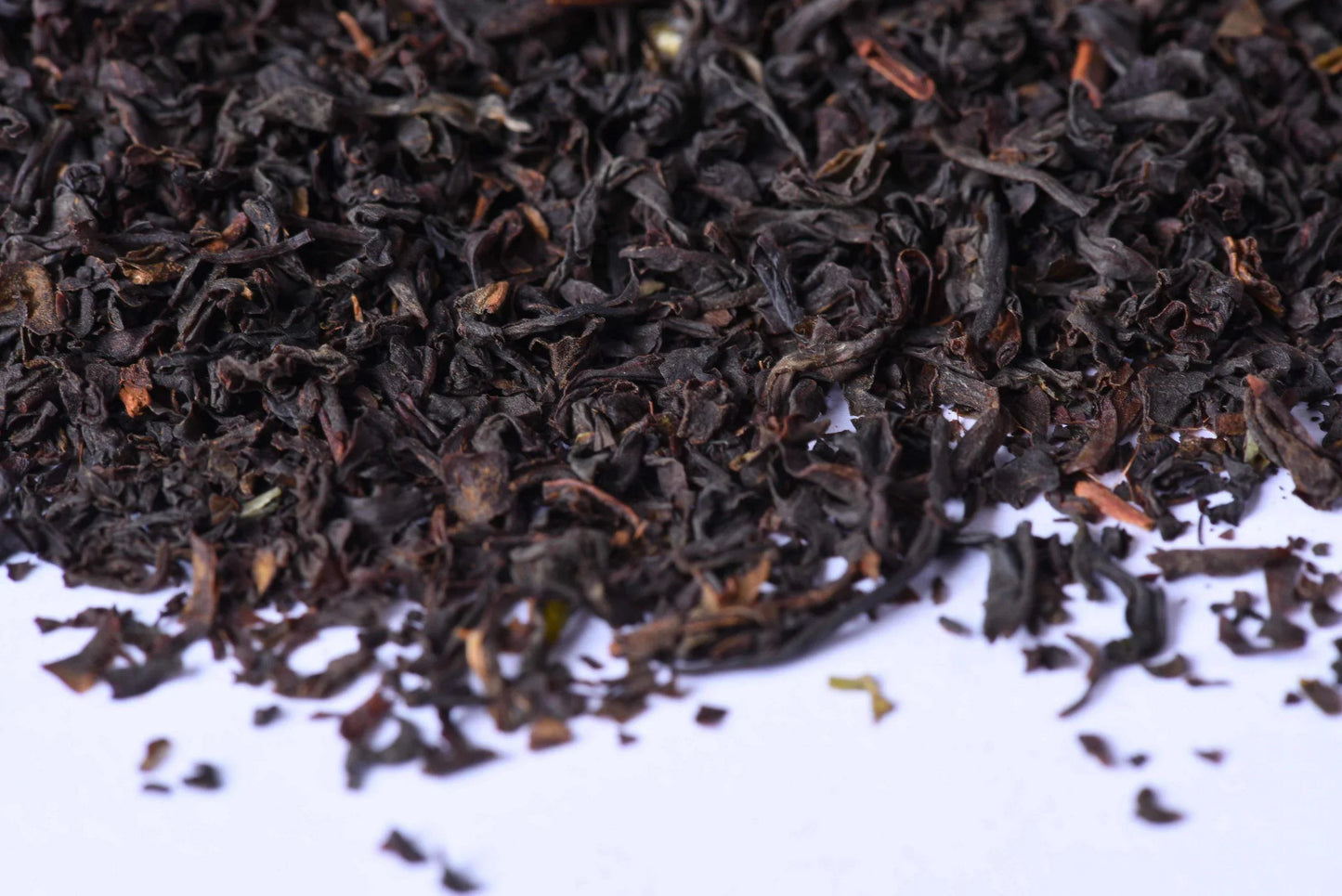 Loose-leaf black tea leaves close-up on white background