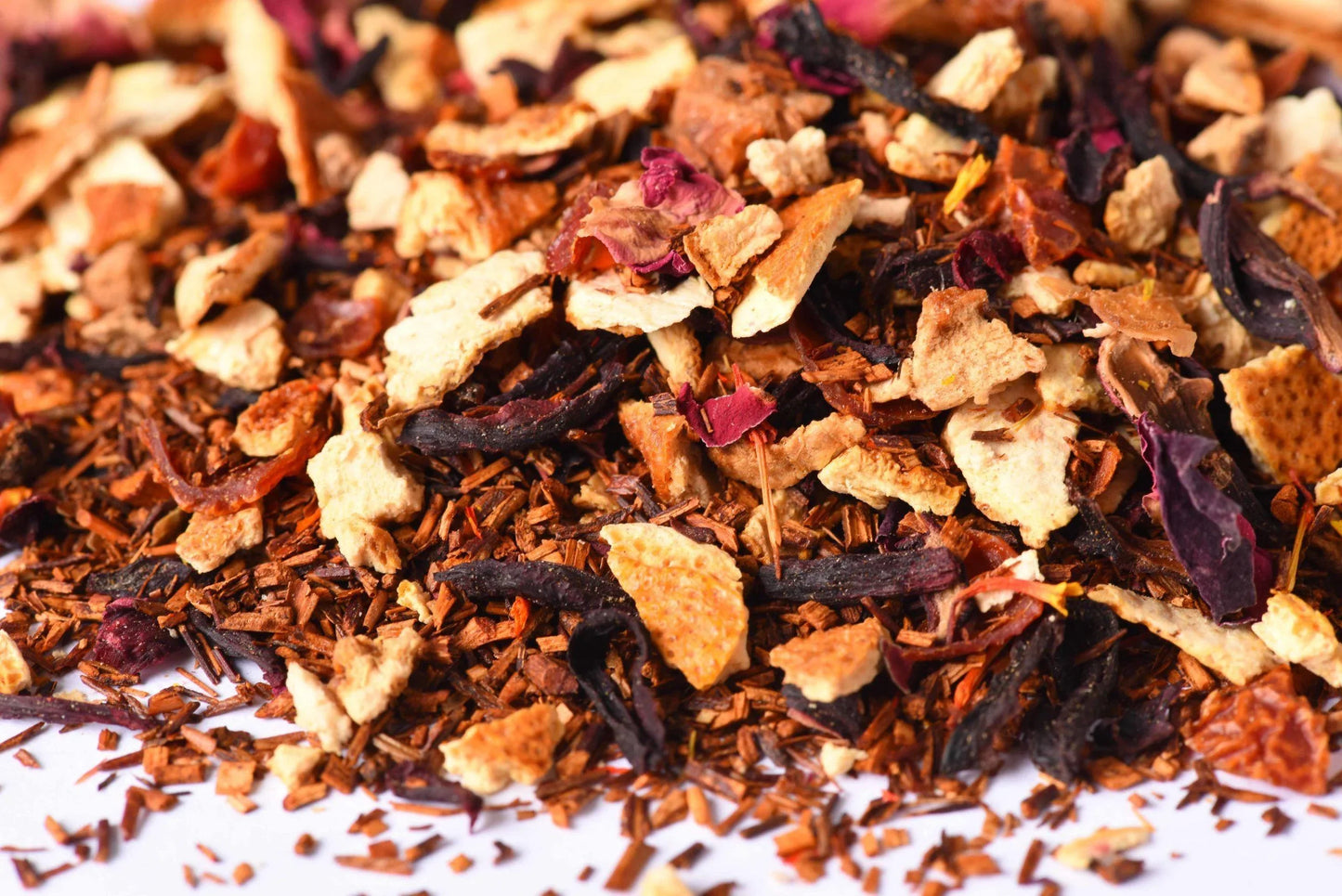 Loose-leaf herbal tea blend with dried fruit, hibiscus petals, and rooibos pieces