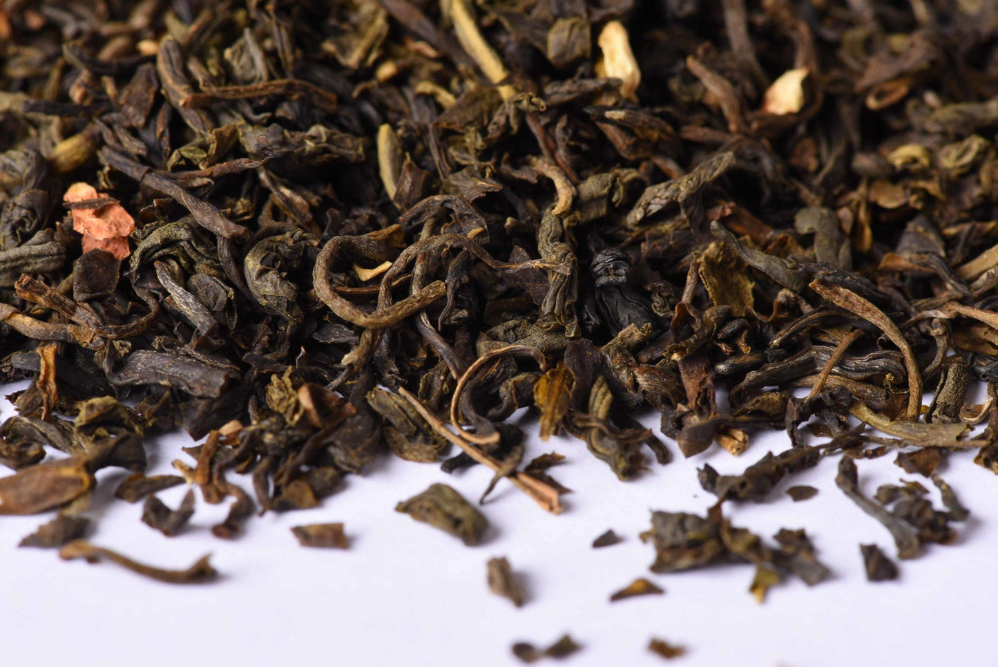 Close-up of loose leaf black tea blend on white background