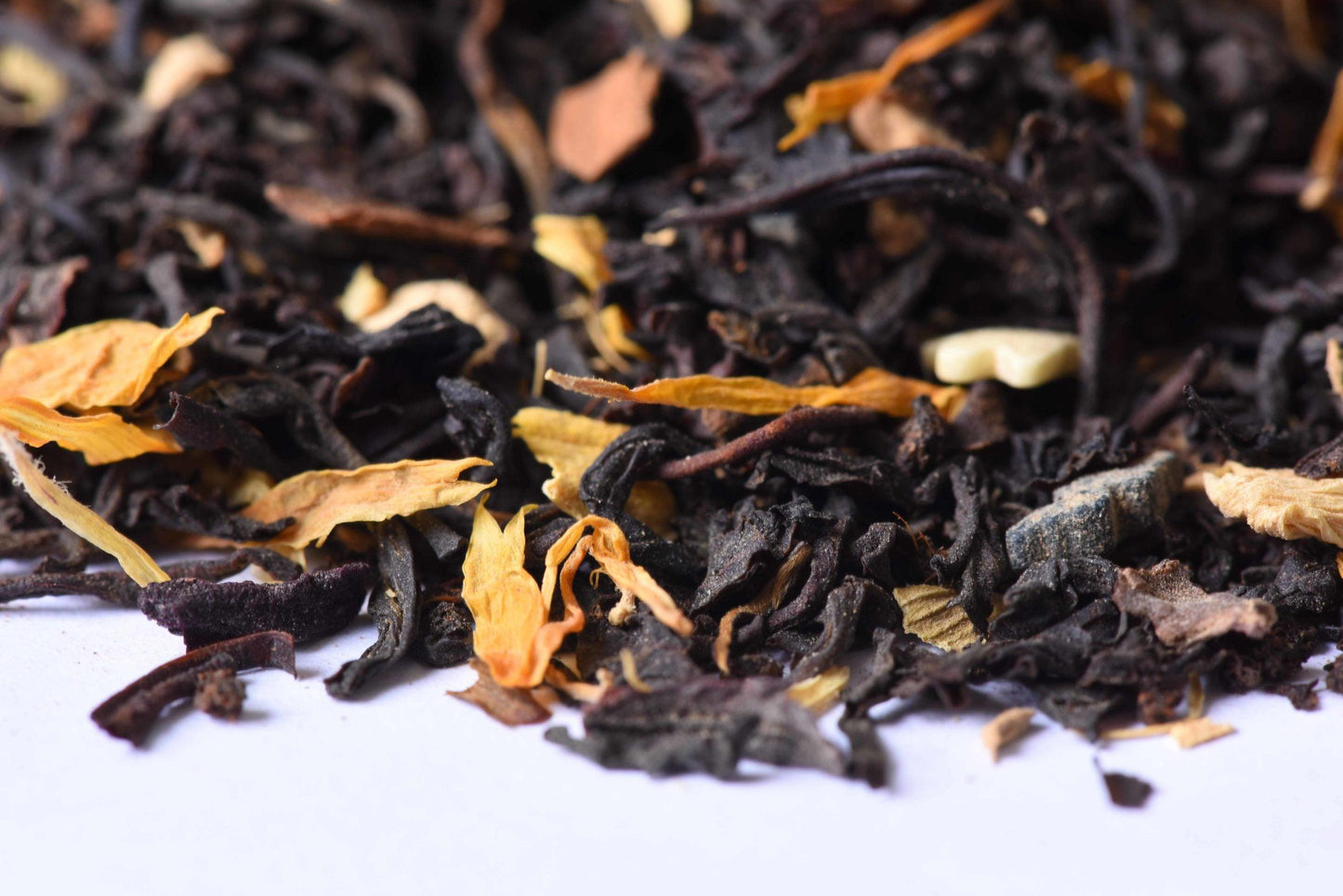 Loose-leaf black tea blend with dried flower petals on white background