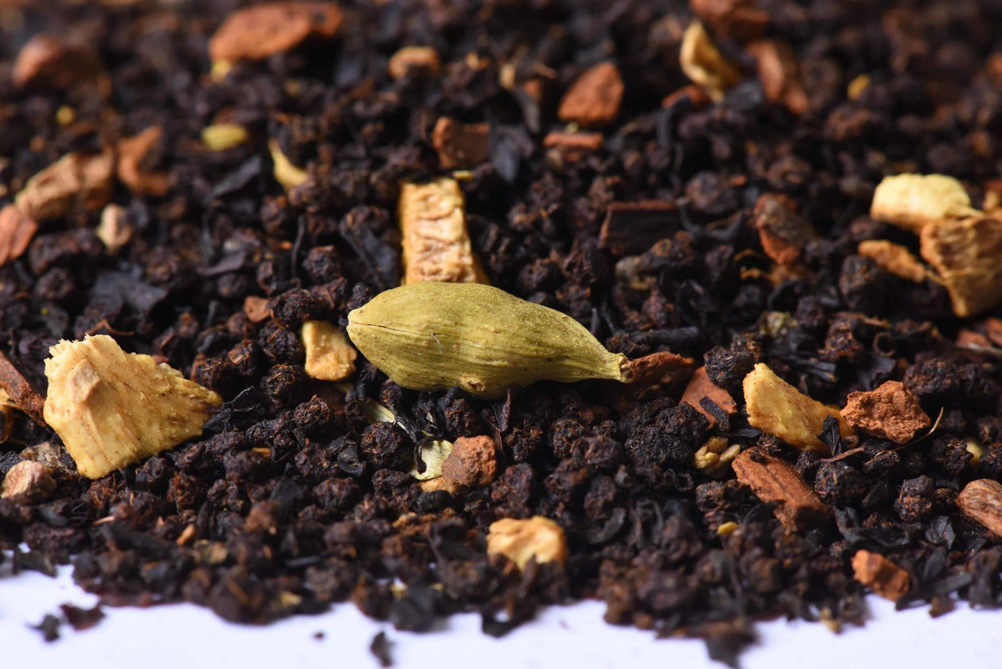 Loose leaf chai tea blend with cardamom, ginger, and black tea leaves close-up