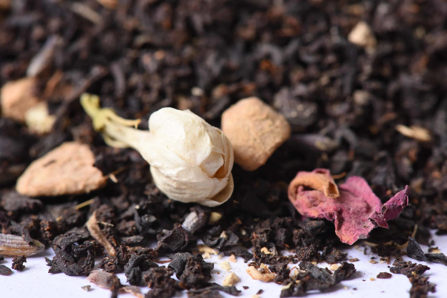 Loose-leaf black tea blend with dried jasmine bud, rose petal, and ginger pieces