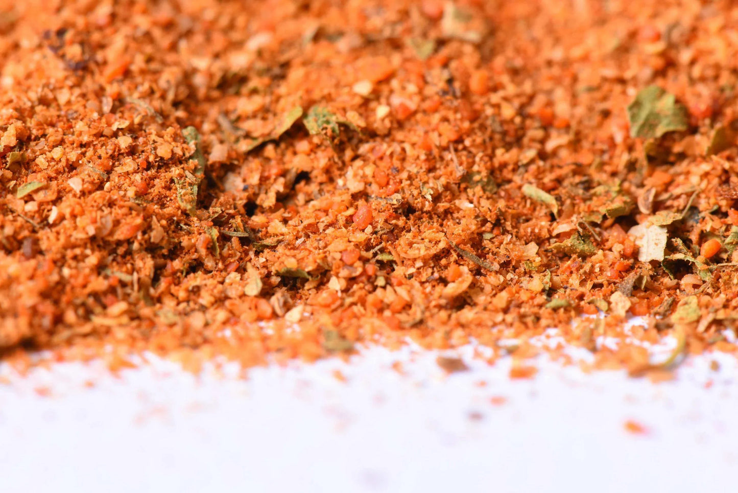 Close-up of vibrant gourmet spice blend with herbs and seasonings on white background