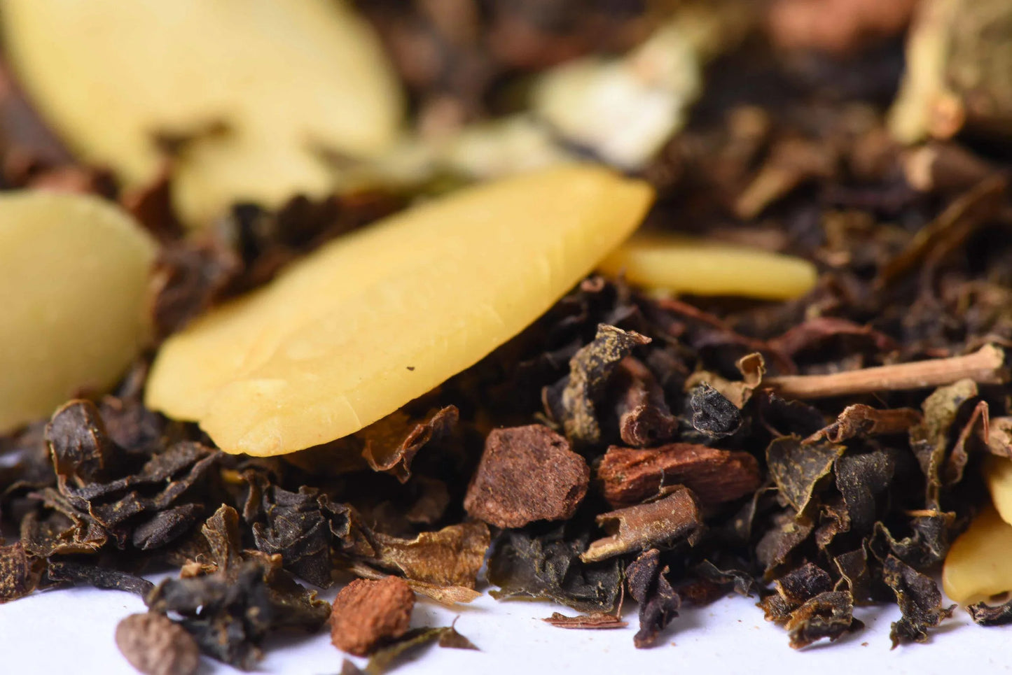 Close-up of loose-leaf gourmet tea blend with almond slices and spice pieces