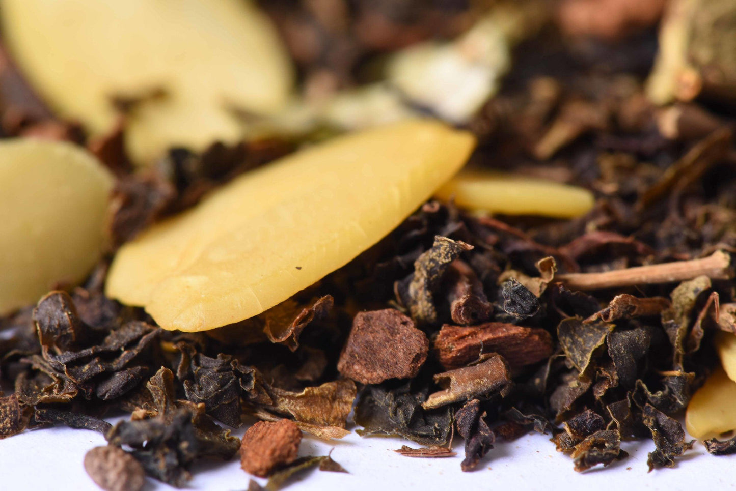 Close-up of loose-leaf gourmet tea blend with almond slices and spice pieces