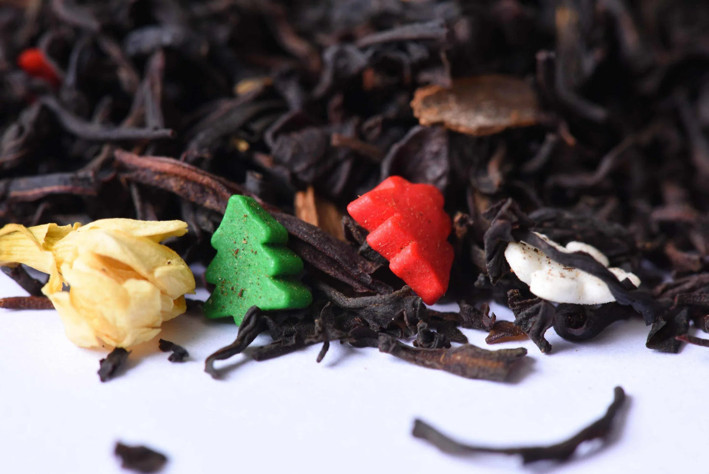Loose-leaf black tea with festive holiday sprinkles and a yellow flower petal