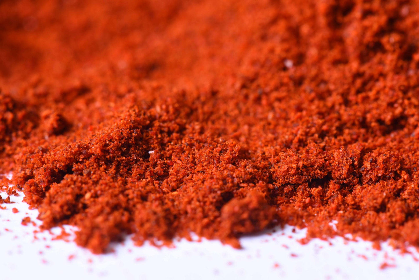 Close-up of vibrant red ground spice blend, fresh and finely milled for cooking.