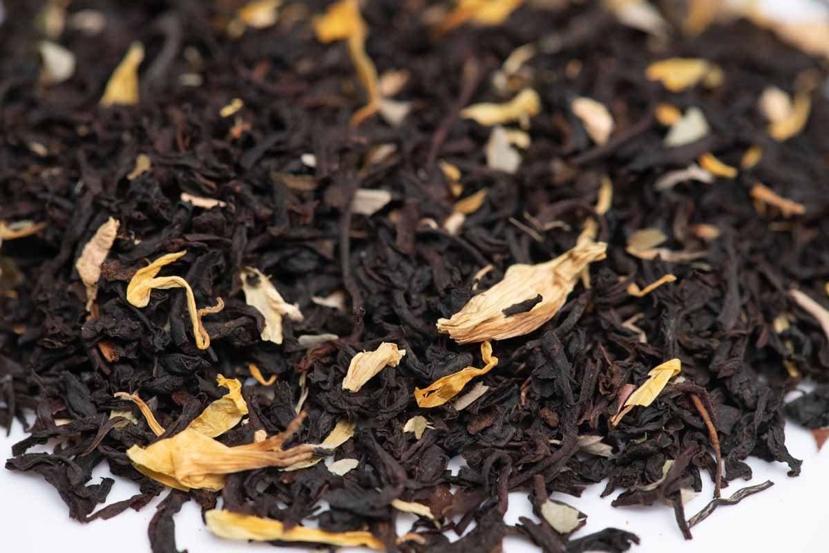 Loose-leaf black tea blend with dried yellow flower petals, close-up view
