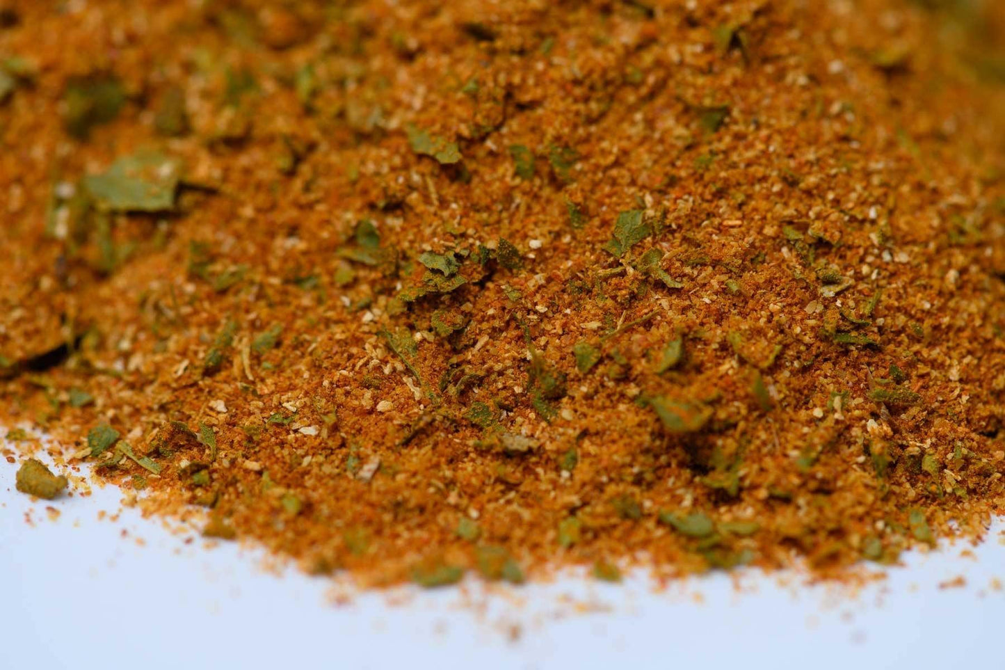 Close-up of blended spice mix with herbs and seasoning on white background