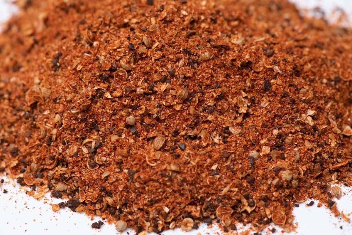 Close-up of a pile of gourmet spice blend with visible herbs and seasonings