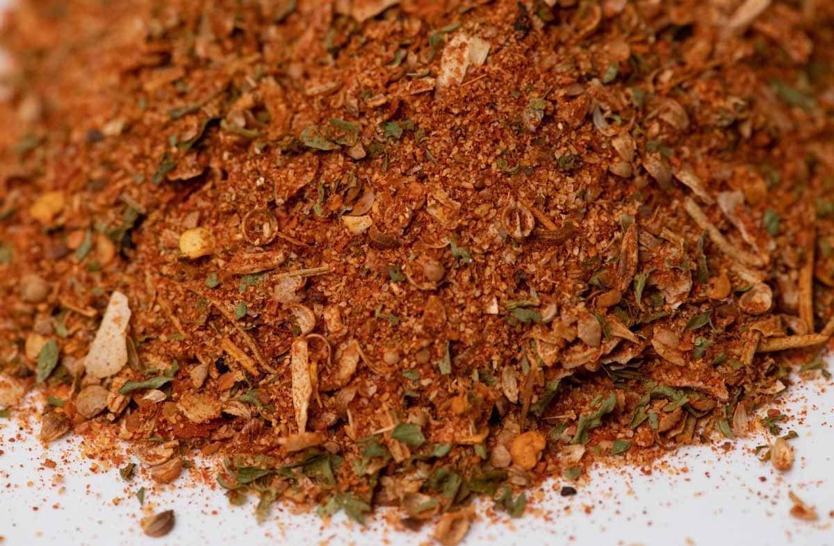 Closeup of gourmet spice blend with herbs and seasonings on a white surface