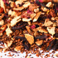 Loose-leaf herbal tea blend with dried fruit, hibiscus petals, and rooibos pieces