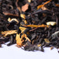 Loose-leaf black tea blend with dried flower petals on white background