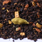 Loose leaf chai tea blend with cardamom, ginger, and black tea leaves close-up