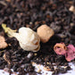 Loose-leaf black tea blend with dried jasmine bud, rose petal, and ginger pieces