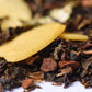 Close-up of loose-leaf gourmet tea blend with almond slices and spice pieces