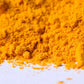 Bright yellow turmeric powder spice close up on white background