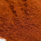 Close-up of fresh, ground red spice blend seasoning on a white background